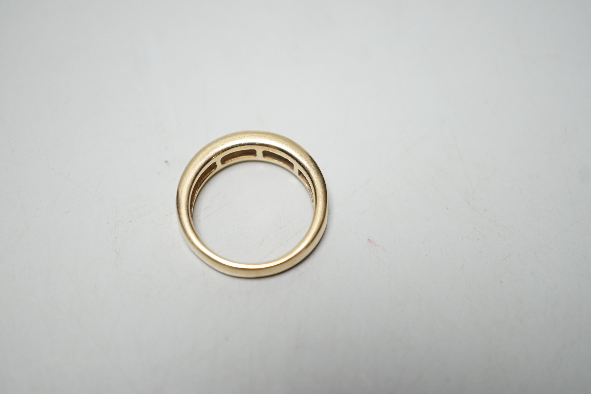 A modern 14k yellow metal and graduated baguette and trapeze cut diamond set half eternity ring, size N, gross weight 4.6 grams.